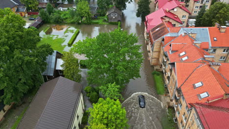 Aerial-view-following-a-car-driving-through-flooding-streets-in-a-European-city