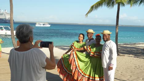 Tourists-taking-photos-with-locals-in-traditional-dress-on-a-sunny-beach