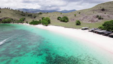 Enjoy-a-tranquil-view-of-a-boat-anchored-near-the-stunning-Pink-Beach-in-Komodo-National-Park,-with-its-unique-pink-sand-and-crystal-clear-waters-as-a-backdrop