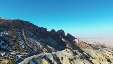 Snow-covered-mountains-in-Afghanistan,-set-against-a-serene,-wintry-environment,-Aerial-landscape-of-snow-capped-mountains-in-Afghanistan