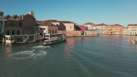 Vaporetto-Fahrt-Durch-Die-Malerischen-Kanäle-Von-Murano,-Venedig,-Mit-Historischen-Gebäuden-Und-Lebendiger-Architektur-An-Einem-Sonnigen-Tag