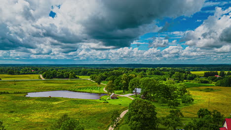 Wooden-House-By-The-Lake-Surrounded-By-Green-Natural-Landscape-In-Summer