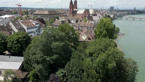 4K-Drone-Video-of-Historic-Church-on-the-banks-of-the-Rhine-River-in-Downtown-Basel,-Switzerland