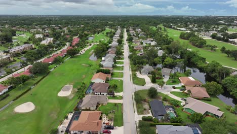 Vista-Aérea-Lateral-Del-Suburbio-De-Nápoles-Con-Campo-De-Golf-Y-Villas-De-Lujo-En-Verano