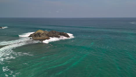 Drone-shot-of-Surfers-surfing-at-Seger-beach-kuta,-Lombok,-Indonesia