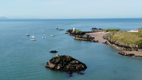 Luftaufnahme-Der-Annäherung-An-Festgemachte-Yachten-Am-Atemberaubenden,-Friedlichen-Strand-Der-Walisischen-Insel-Ynys-Llanddwyn