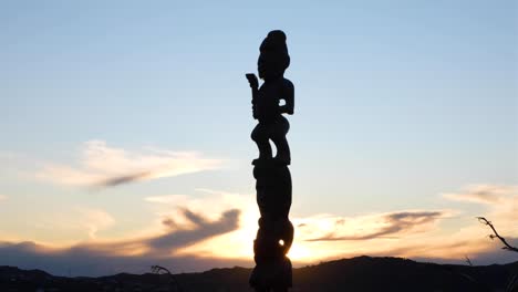 Close-up-of-cultural-Maori-pou-whenua-carved-wooden-statue-at-Mt-Vic-lookout-with-views-of-Wellington,-New-Zealand-Aotearoa