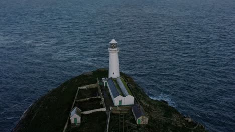 Vista-Aérea-Del-Faro-De-South-Stack-Que-Rodea-Una-Isla-Accidentada,-Un-Hito-Náutico,-Durante-El-Amanecer