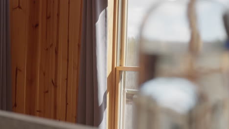 Cozy-cabin-window-with-water-in-foreground