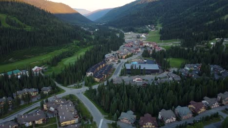 Vista-Aérea-De-Un-Pueblo-De-Esquí-Y-Un-Valle-Montañoso-Verde-En-Canadá