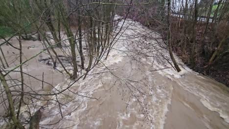 Dirty-flood-water-flowing-fast-in-the-river,-abstract-close-up