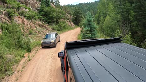 POV---View-of-vehicle-rooftop-driving-in-Phantom-Canyon-in-Colorado-with-on-coming-traffic