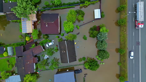 Birds-eye-drone-shot-of-homes-covered-in-dirty-water,-after-torrential-rain