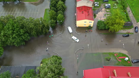 Calle-De-La-Ciudad-Inundada,-Automóvil-Remolcado-En-Una-Carretera-Sumergida,-Vista-Aérea-Desde-Arriba