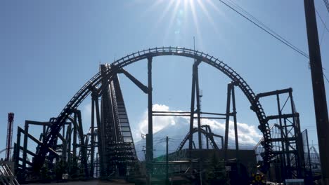 Roller-Coaster-ride-moving-up-at-Fuji-Q-Highland-with-Mount-Fuji-in-the-Background,-Japan