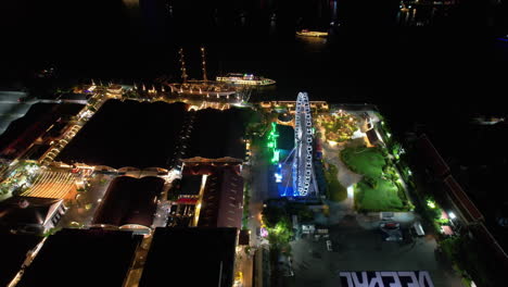 Drone-Volando-Sobre-La-Ribera-Del-Río-Asiatique-Y-El-Río-Chao-Phraya,-De-Noche-En-Bangkok,-Tailandia