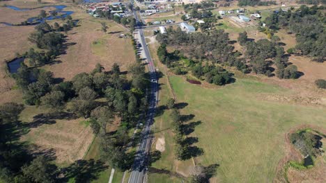 Road-Between-Green-Fields-In-Kilcoy-Town-In-Queensland,-Australia---Aerial-Shot