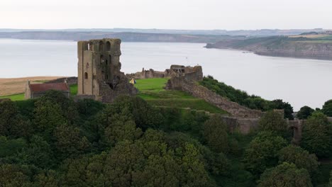 Aerial-drone-view-of-Scarborough-Castle-in-Scarborough,-North-Yorkshire-taken-early-morning-on-an-overcast-day-in-summer