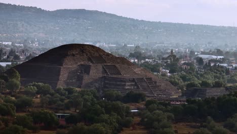 Teotihuacan's-Pyramid-of-Moon-facade,-surrounded-by-lush-green-vegetation,-Mexico