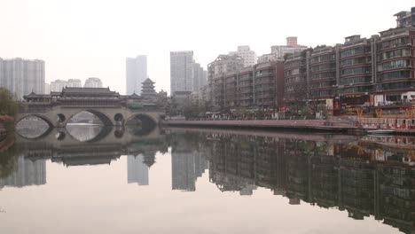 panoramic-view-of-tilt-Chengdu-capital-city-of-the-Chinese-province-of-Sichuan,-Anshun-Bridge-over-the-Jin-river-with-modern-skyline-skyscraper