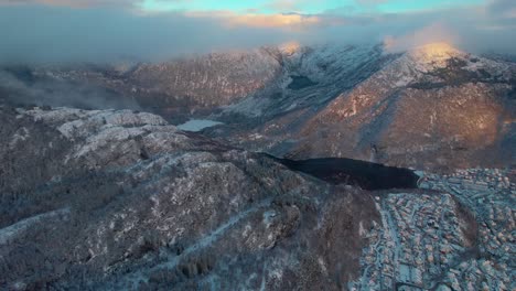 Bergen-establishing-shot-of-city-buildings-with-view-of-mountains,-winter-day,-aerial-drone