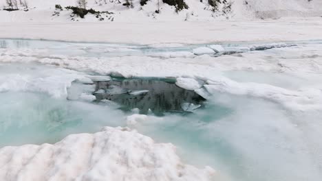 Serene-winter-landscape-capturing-pools-of-water-amidst-snow-and-ice-in-the-Valmalenco-Alps,-Lombardy,-Italy