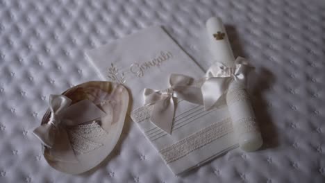 Baptism-set-featuring-embroidered-towel,-candle,-and-bonnet-with-delicate-ribbons