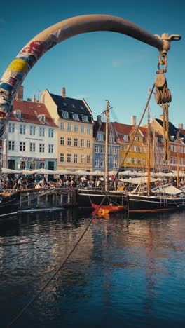 Vertical-view-of-Copenhagen's-iconic-seafront-at-Nyhavn-on-a-summer-evening