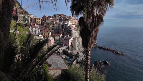 Picturesque-view-of-Manarola,-Italy,-with-colorful-houses-perched-on-cliffs-overlooking-the-sea-horizon,-capturing-the-charm-and-beauty-of-this-coastal-village