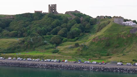 Aerial-drone-view-of-Scarborough-Castle-in-Scarborough,-North-Yorkshire-taken-early-morning-on-an-overcast-day-in-summer