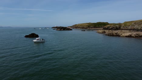 Establishing-tourist-boat-aerial-view-moored-on-stunning-Ynys-Llanddwyn-peaceful-Welsh-island-beach