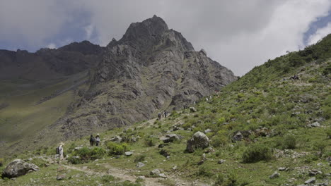 Touristen-Steigen-Vom-Humantay-Rocky-Mountain-über-Eine-Straße-Zwischen-Grünen-Feldern-Ab