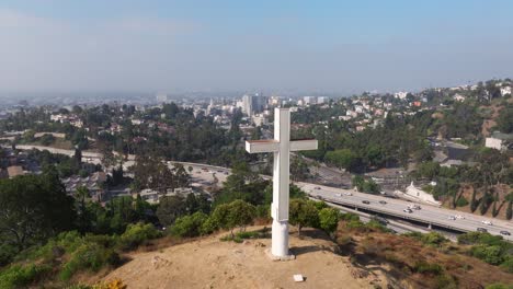 Luftumlaufbahn-Direkt-Um-Weißes-Metallkreuz-Mit-Blick-Auf-Den-Highway-In-Los-Angeles,-Kalifornien