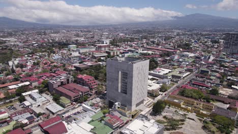 Luftaufnahme-Der-Gesetzgebenden-Versammlung-Von-Costa-Rica,-Umgeben-Von-Einer-Ausgedehnten-Stadtlandschaft-Unter-Einem-Hellen-Himmel