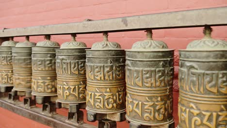 Nepal-Tibetan-Buddhist-Prayer-Wheels-at-Monkey-Temple-in-Kathmandu,-Close-Up-of-Prayer-Wheels-Spinning,-Religious-Symbol-used-for-Praying-at-a-Buddhist-Temple,-a-Popular-Tourist-Spot