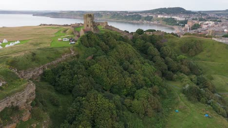 Aerial-drone-view-of-Scarborough-Castle-in-Scarborough,-North-Yorkshire-taken-early-morning-on-an-overcast-day-in-summer