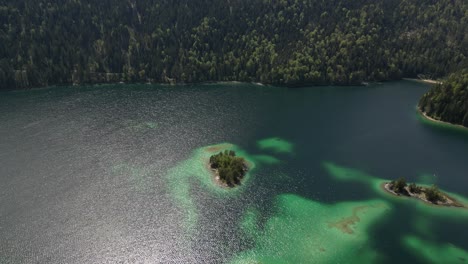 Aerial-view-of-Eibsee-lake-surrounded-by-lush-green-forests-an-mountains,-Grainau,-Germany