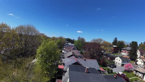 Vuelo-De-Techado-En-Vecindario-Americano-Con-Casas-Unifamiliares-Durante-Un-Día-Soleado-Con-Cielo-Azul