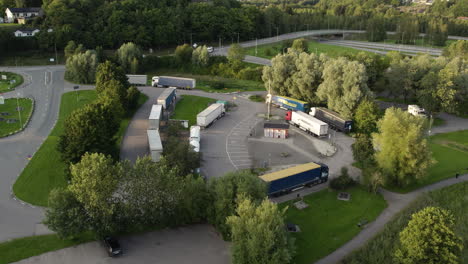 Trailers-Taking-a-Break-at-the-Rest-Area-on-Highway-E6-in-Ljungskile,-Bohuslan,-Sweden---Orbit-Drone-Shot