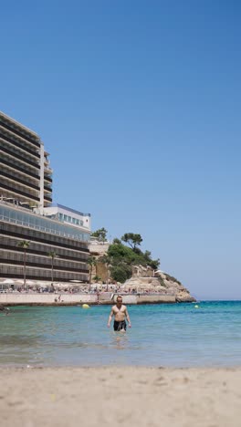 Vertical-view-of-male-tourist-in-turquoise-water-enjoy-vacation-in-Mallorca