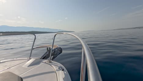 Boot-Fährt-Auf-Ruhigem-Meer-Mit-Bergen-In-Der-Ferne-Unter-Klarem-Himmel