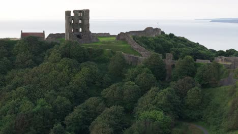 Aerial-drone-view-of-Scarborough-Castle-in-Scarborough,-North-Yorkshire-taken-early-morning-on-an-overcast-day-in-summer