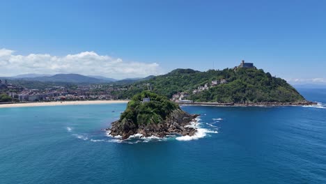 Insel-Santa-Clara,-San-Sebastian,-Spanien,-Schwenk-Drohne,-Luftaufnahme,-Blauer-Himmel