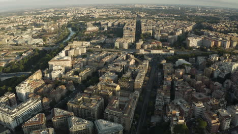 Aerial-dolly-above-Trastevere-neighborhood-Rome-Italy-and-train-station-by-river-at-sunset