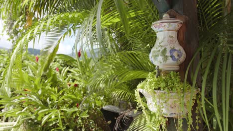 Palm-tree-branches-with-flower-pots-in-exotic-resort,-motion-view