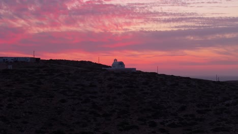 Órbita-Panorámica-Alrededor-De-La-Iglesia-De-La-Santa-Sabiduría-En-Donousa,-Grecia,-Durante-La-Impresionante-Puesta-De-Sol