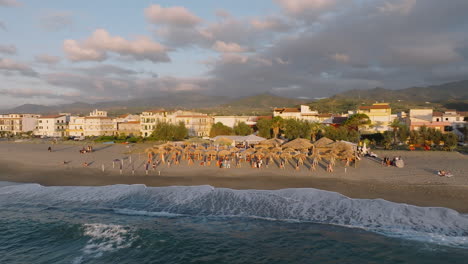 4K-Aerial-Slow-pull-back-of-beach-restaurant-Portorosa-at-sunset