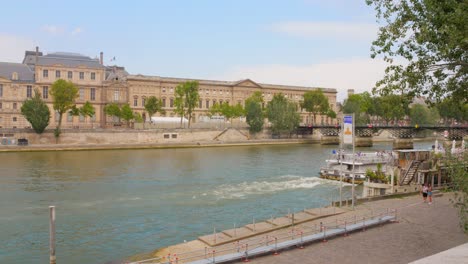 Profile-view-of-historic-Louvre-and-Seine-River-where-the-Olympic-boats-passed-for-the-opening-ceremony-in-Paris,-France-during-daytime