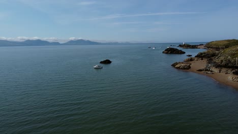 Luftaufnahme-Eines-Einzelnen-Touristenboots,-Das-Am-Atemberaubenden,-Friedlichen-Walisischen-Inselstrand-Von-Ynys-Llanddwyn-Festgemacht-Ist