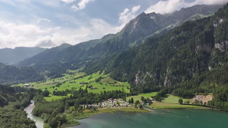 Vista-Aérea-Del-Lago-Klöntalersee-Con-Los-Majestuosos-Alpes-Suizos-De-Fondo,-Glaris-Süd,-Suiza,-Que-Enfatiza-El-Concepto-De-Impresionantes-Paisajes-Naturales-Y-Grandeza-Alpina